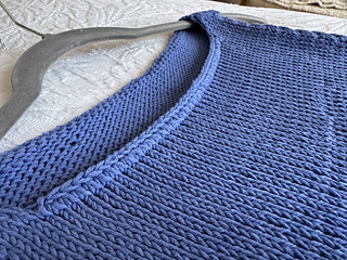 Non-rolling edge worked along the front and back neck edges