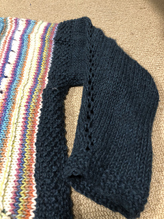 Eyelet detail down centre line of sleeve, moss stitch hem at wrist 