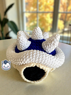 Crochet Amigurumi of the Blue Spiny Shell from Mario Kart made with soft blue and white yarn.
