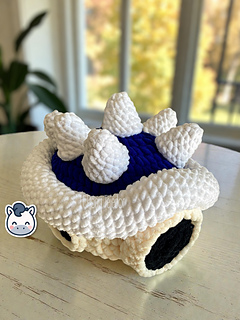 Crochet Amigurumi of the Blue Spiny Shell from Mario Kart made with soft blue and white yarn.