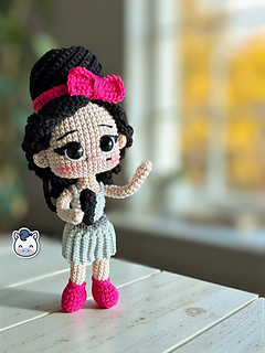 Patrón de ganchillo amigurumi inspirado en Amy Winehouse, muñeca tejida a crochet con peinado característico y vestido azul.
Amy Winehouse inspired crochet amigurumi pattern, handmade doll with iconic hairstyle and blue dress.