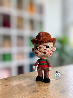 Handmade Freddy Krueger amigurumi crochet doll with brown hat and red and green striped sweater, PDF pattern for horror movie fans and geek collectors.
