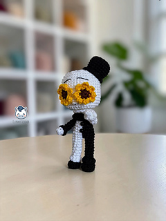 Handmade Art the Clown amigurumi inspired by Terrifier, featuring the iconic black-and-white costume, creepy facial details, and sunflower accessory in a detailed PDF crochet pattern for horror movie and amigurumi fans.