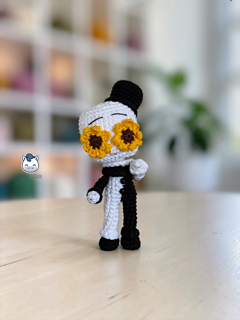 Handmade Art the Clown amigurumi inspired by Terrifier, featuring the iconic black-and-white costume, creepy facial details, and sunflower accessory in a detailed PDF crochet pattern for horror movie and amigurumi fans.