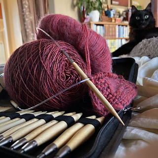 Swatching it together with madelinetosh Prairie in Byzantine, which blends surprisingly well while adding a touch of variegation and bringing it up to more of a worsted weight. On 5.5mm needles.
The yarn is not this purple-ish.
