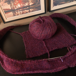 Just added second skein. First got me the pictured swatch and about 3 inches of sweater (in the round). The color is darker than this photo depicts.