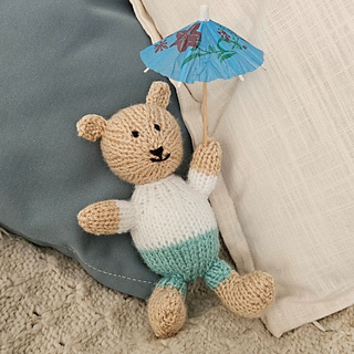 Knitted teddy bear with trouser and t-shirt option and a cocktail stick