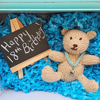 Knitted teddy bear gift idea in shoe box with slate sign