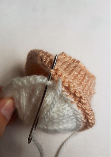 Knitted cherry bakewell sewing icing to pastry bottom