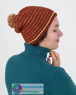 A woman tries on a textured crochet hat with a mosaic pattern.