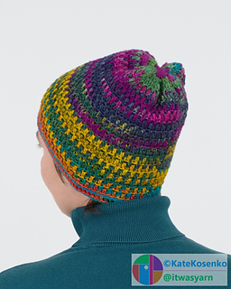 A woman wears a textured crochet hat with colorful stripes created by self-striping yarn.