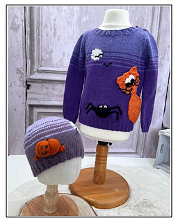 Scaredy Cat jumper on a stand with the matching pumpkin hat from the Halloween Hats knitting pattern