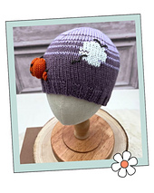 Purple kids Halloween hat with a small knitted pumpkin and a duplicate stitch moon, Halloween Hats knitting pattern
