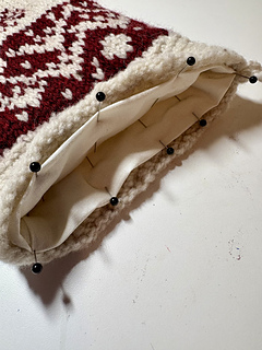 After seaming, keeping the lining as sewn, stuff into stocking, fold under two inches cuff and pin.