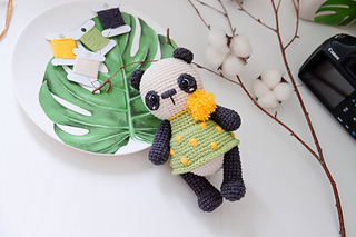 Little Panda crochet toy with decorated green skirt and yellow puff details