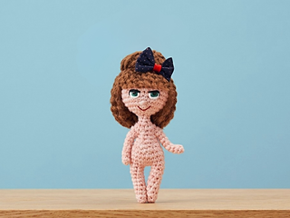 photo shows the real handmade crochet Doll displayed on a digitally edited background for presentation purposes
