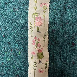 Lovely Acufactum ribbon makes a charming button band facing and keeps the snaps from tugging too hard on the knitted fabric.