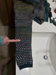 2025:  in reply to a message:  it looks like I did a few decreases at the top, ut then stopped doing them.  I don't like tights sleeves and Andrea clearly does.  About where my finger is / elbow zone I just stopped decreasing until just above the cuff.