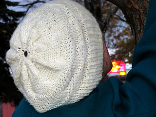 [Image Description: someone wearing a white hat with a textured knit and purl pattern.]