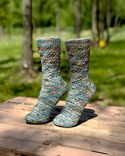 Image Description: a pair of ribbed lace socks knit in a multicolour variegated yarn
