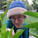 [Image Description: A woman wearing a blue cabled knit hat with the brim folded up, revealing an off-white layer underneath.]