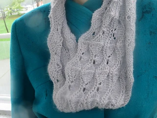 [Image Description: someone wearing a grey knit lace cowl in a scalloped lace pattern.] 