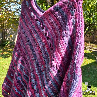 Close-up view of textured crochet stitches showing floral stitch combinations, clusters, and front post detailing in a colorful poncho design.