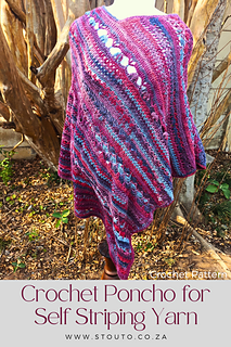 A woman wearing a colorful floral stitched crochet poncho made with self-striping yarn while standing outdoors during autumn with soft flowing drape and textured stitch detail.
