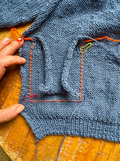 Using Cocoknits method with scrap yarn as guide for sewing down pocket linings.