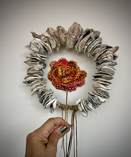 An alternative generic flower can also be knit, transformed by the yarn color way selected. It's mounted onto a wooden knitting needle, just pierced through the center!