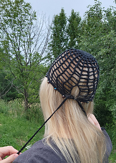 Finished handmade crochet accessory, a black summer hat with beaded details.