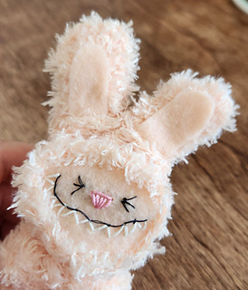 A close-up shot of the Labubu doll's face, highlighting the expressive eyes and the neat