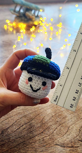 A hand holding the RISE mascot to demonstrate the finished toy size.