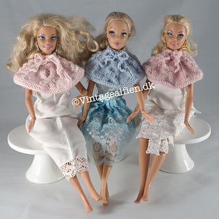 Three Barbie dolls having a chat all wearing different designs of the Susie cape