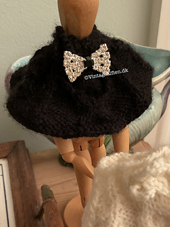 A cape with honeycomb cable and a bow shaped button 