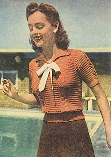JUST the handiest addition to your winter wardrobe—a jumper knitted in warm rust-colored wool. The short sleeves and bow at the neck, where the revers tum back, are youthful touches.