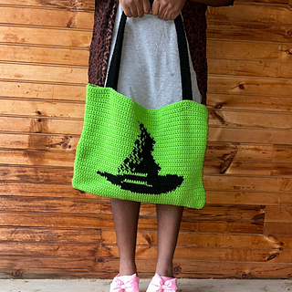 Model holds green and black tote bag