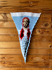 White and blue crochet pennant features image of Dorothy Gale
