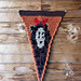 Crochet pennant against a wooden wall