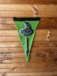Crochet pennant against a wooden wall