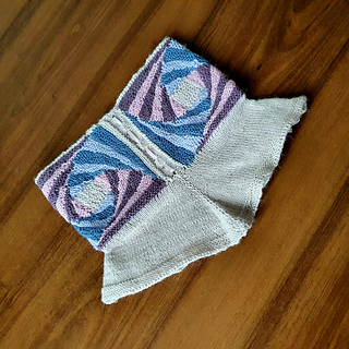 a knitted spiral striped cowl with flared yoke and ribbon lacing.