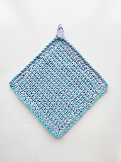 Tunisian crocheted square cloth with hanging loop, worked in a turquoise and lavender pattern on a white background.