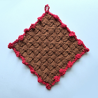 Brown basketweave knitted square with red bobble border and hanging loop