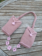 Table with pink crocheted bag with flowers