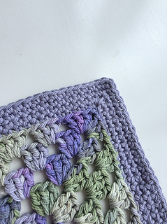Crocheted lavender, green, and cream granny square corner