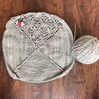 A silvery-grey shawl in progress on circular needles.  Pattern is A Joyful Thread