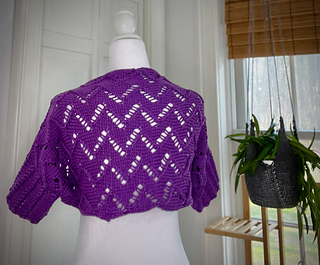 full back of Madeira shrug on dress form with plant and window on the right