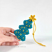 Handmade crochet Christmas tree with imitation garland and "star" on top, showcasing the result of a detailed amigurumi pattern.