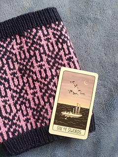 Way Home Cowl, DK version, with the 6 of Swords card from the Fifth Spirit Tarot Deck, by Charlie Claire Burgess. This card is part of the inspiration for this cowl.